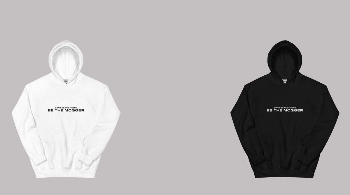 The Don't Be The Friend, Be The Mogger hoodie in white and the zip hoodie in black on a grey studio wall